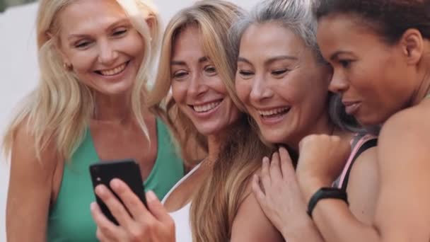 Mulheres Adultas Multinacionais Alegres Olhando Para Telefone Livre — Vídeo de Stock