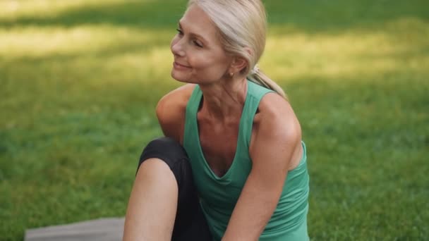 Smiling Woman Sitting Yoga Mat Park — Stock Video