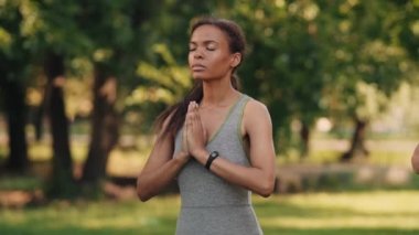 Yoğunlaşmış Afrikalı olgun kadın dışarıda meditasyon yapıyor.