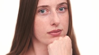 Beyaz stüdyoda düşünen düşünceli bir kadının yakın plan görüntüsü