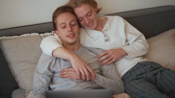 Leende Homosexuella Par Tittar Laptop Och Pratar Medan Ligger Sängen — Stockvideo