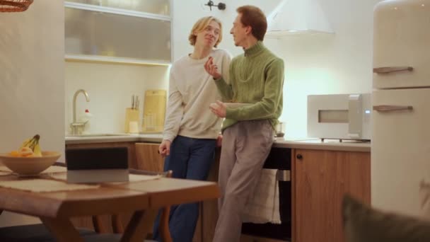 笑いゲイのカップルがキッチンで話している — ストック動画