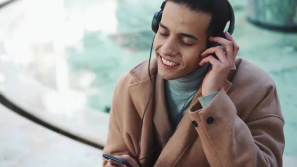 Χαμογελώντας Άραβας Άνθρωπος Ακούγοντας Μουσική Στα Ακουστικά Στο Πάρκο — Αρχείο Βίντεο