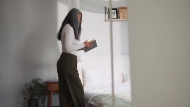 Sorrindo Mulher Asiática Andando Para Ler Livro Cama — Vídeo de Stock