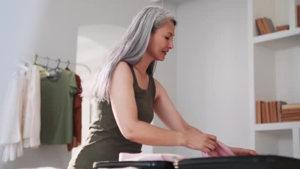 亚洲女人在家里把东西装进行李箱 — 图库视频影像