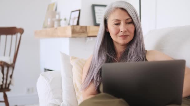 Pensive Ασιάτισσα Γυναίκα Κοιτάζοντας Φορητό Υπολογιστή Στο Σπίτι — Αρχείο Βίντεο