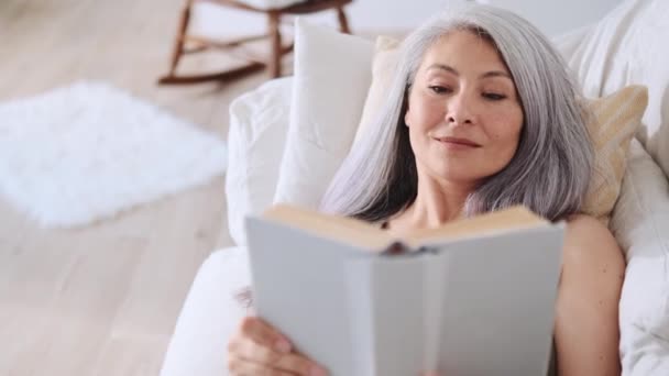 Asiática Feliz Mujer Leyendo Libro Casa — Vídeos de Stock