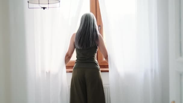 Πίσω Όψη Γκριζομάλλης Γυναίκας Που Κοιτάζει Παράθυρο Στο Σπίτι — Αρχείο Βίντεο