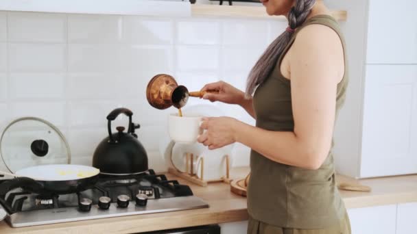 Frau Gießt Kaffee Aus Türke Tasse — Stockvideo