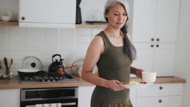 Asian Mature Woman Brings Her Breakfast Table — Stock Video