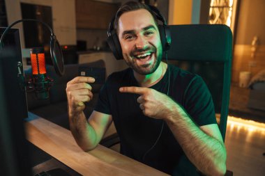 Kulaklıkla oynayan mutlu genç oyuncu flaması. Oyuncularla sohbet ediyor. Oyun yarışmasında sohbet ediyor.