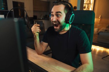 Kulaklıkla oynayan mutlu genç oyuncu flaması. Oyuncularla sohbet ediyor. Oyun yarışmasında sohbet ediyor.