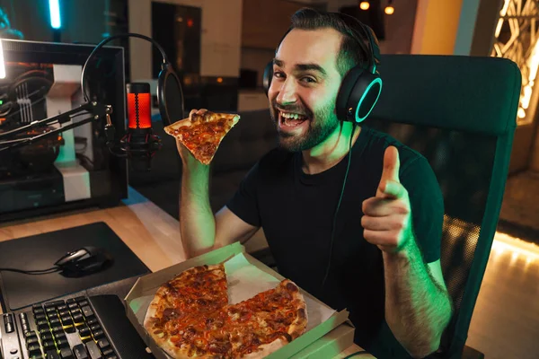 Hombre Joven Feliz Auriculares Con Ordenador Comer Pizza Mientras Juega —  Fotos de Stock
