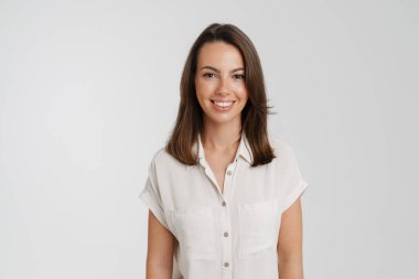 Genç Avrupalı kadın gülümsüyor ve beyaz arka planda izole edilmiş kameraya bakıyor