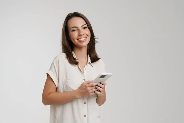 Joven Morena Sonriendo Mientras Usa Teléfono Celular Aislado Sobre Fondo — Foto de Stock