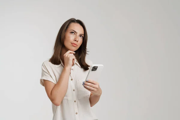 Young European Woman Looking Upward While Using Mobile Phone Isolated — Stock Photo, Image