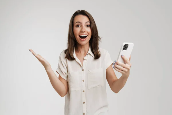 Mladá Žena Usmívá Gestikuluje Při Použití Mobilu Izolované Přes Bílé — Stock fotografie