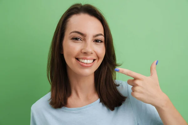 Młoda Europejka Shircie Wskazuje Palcem Swój Uśmiech Odizolowany Zielonego Tła — Zdjęcie stockowe