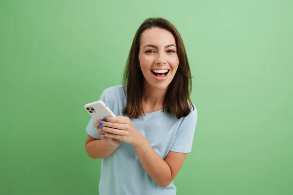 Young Brunette Woman Laughing While Using Cellphone Isolated Green Background — Stock Photo, Image