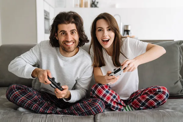 Młoda Szczęśliwa Para Trzyma Joysticks Grając Gry Ekranie Telewizora Podczas — Zdjęcie stockowe