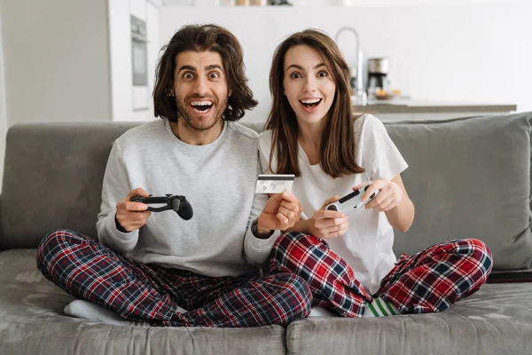 Young Multiracial Couple Using Credit Card While Playing Online Game — Stock Photo, Image