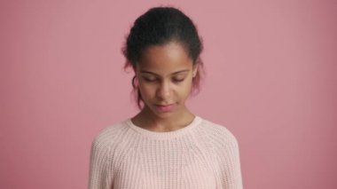 Pozitif Afrikalı küçük kız pembe stüdyoda seviniyor.