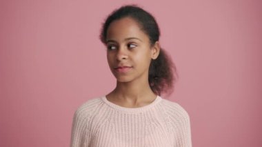 Pozitif Afrikalı küçük kız pembe stüdyoda seviniyor.