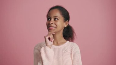 Pozitif Afrikalı küçük kız pembe stüdyoda seviniyor.