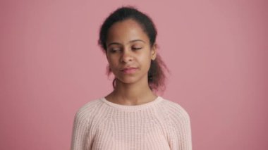 Pozitif Afrikalı küçük kız pembe stüdyoda seviniyor.