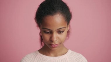 Pozitif Afrikalı küçük kız pembe stüdyoda seviniyor.