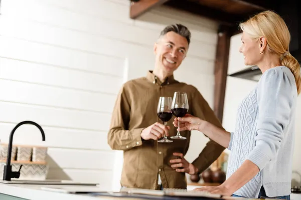 Gülümseyen Orta Yaşlı Çift Mutfakta Kırmızı Şarap Içiyor — Stok fotoğraf