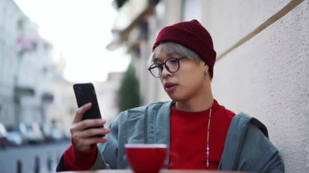 Coreano Sério Cara Olhando Para Telefone Café — Vídeo de Stock