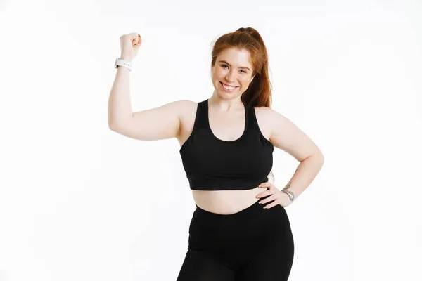 Młoda Ruda Kobieta Uśmiecha Się Pokazując Swój Biceps Odizolowany Białym — Zdjęcie stockowe