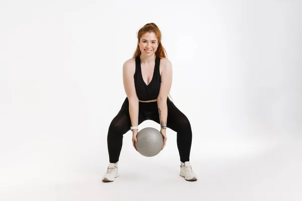 Glimlachende Jonge Fitnessvrouw Sportkleding Die Een Witte Achtergrond Staat Trainen — Stockfoto