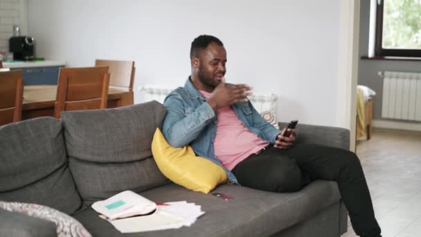 Afrikansk Positiv Man Talar Videosamtal Telefon Hemma Soffan — Stockvideo