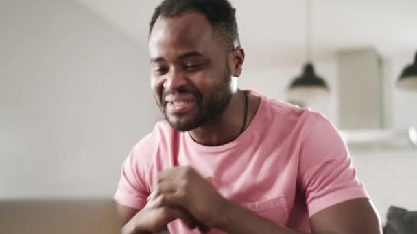 アフリカの笑い男ビデオ通話でラップトップによってザソファ — ストック動画