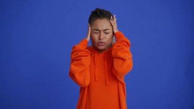 Saçları örgülü gülümseyen Afrikalı kız mavi stüdyoda bir şey hatırlıyor.