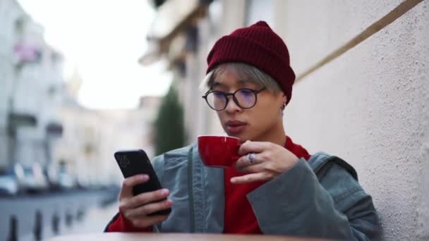 Confiante Asiático Cara Beber Café Olhando Para Telefone Livre — Vídeo de Stock