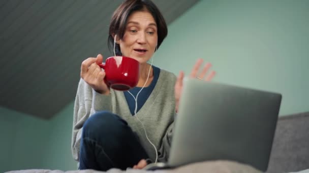 Zamyślona Dojrzała Kobieta Rozmawia Przez Wideo Rozmowy Laptopie Łóżku — Wideo stockowe
