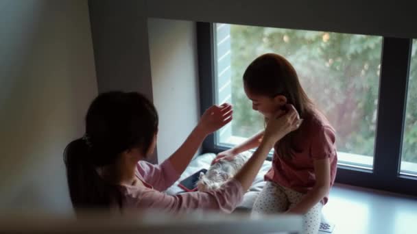Asiatique Maman Peignage Fille Qui Caresse Chien Sur Rebord Fenêtre — Video