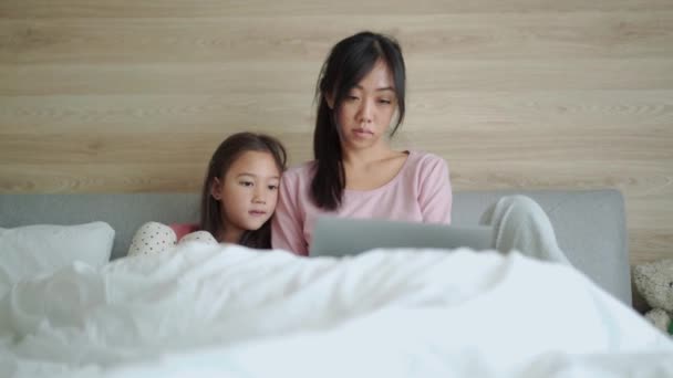 Ciddi Bir Asyalı Anne Kızı Yatağın Üstünde Dizüstü Bilgisayara Bakıyor — Stok video