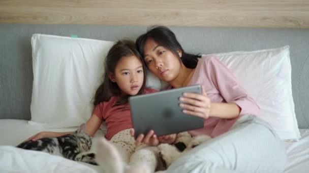 Довірлива Азіатська Мати Дочка Дивляться Табличку Ліжку — стокове відео