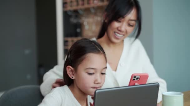 Träumende Asiatische Mädchen Mit Blick Auf Tablet Und Ihre Mutter — Stockvideo