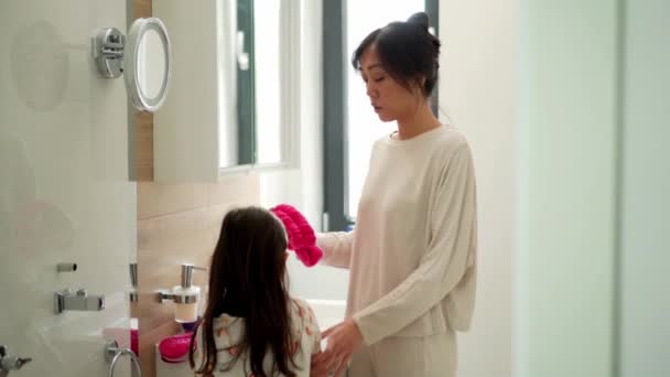 Aziatische Moeder Zet Een Hoofdband Voor Haar Dochter Het Bad — Stockvideo