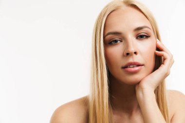 Beyaz arka planda izole edilmiş, poz verip kameraya bakan yarı çıplak sarışın kadın.