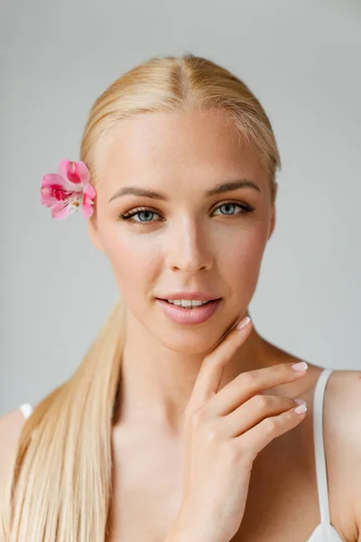 Mujer Rubia Joven Mirando Cámara Mientras Posa Con Flor Aislada — Foto de Stock