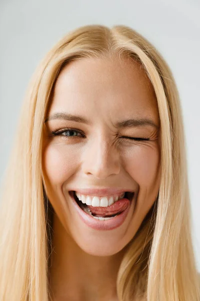 Νεαρή Ξανθιά Γυναίκα Κλείνει Μάτι Ενώ Γλείφει Δόντια Της Απομονωμένη — Φωτογραφία Αρχείου