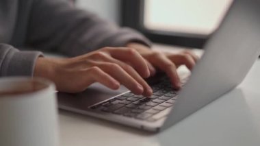 Erkek eller ofiste dizüstü bilgisayarla yazı yazıyor.