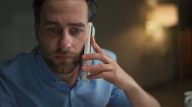 Ofiste telefonla konuşan dalgın bir adam.