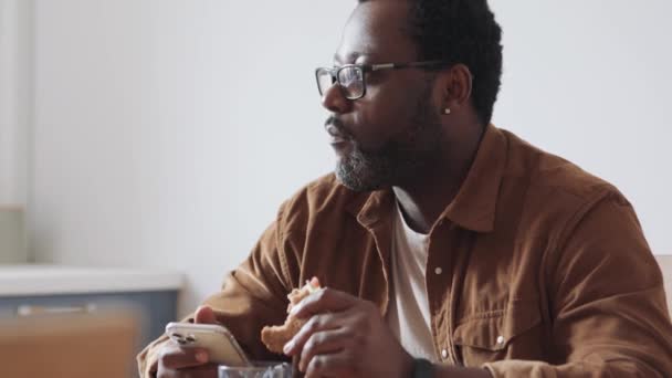 Hombre Africano Serio Comiendo Sándwich Hablando Cocina — Vídeos de Stock